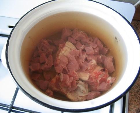 В кастрюлю емкостью 2-2,5 литра перекладываем мясо, заливаем его холодной водой и ставим на огонь