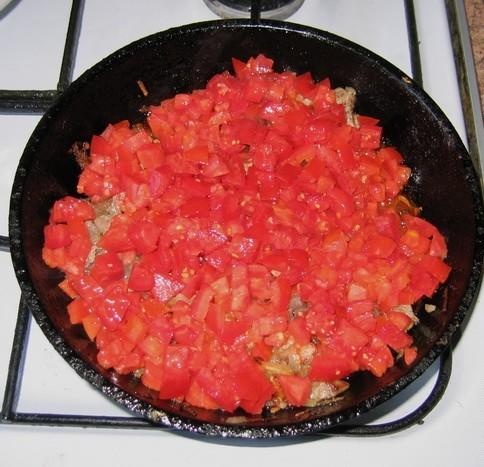 Выкладываем нарезанные помидоры к мясу с луком, перемешиваем и тушим под крышкой еще примерно минут 10